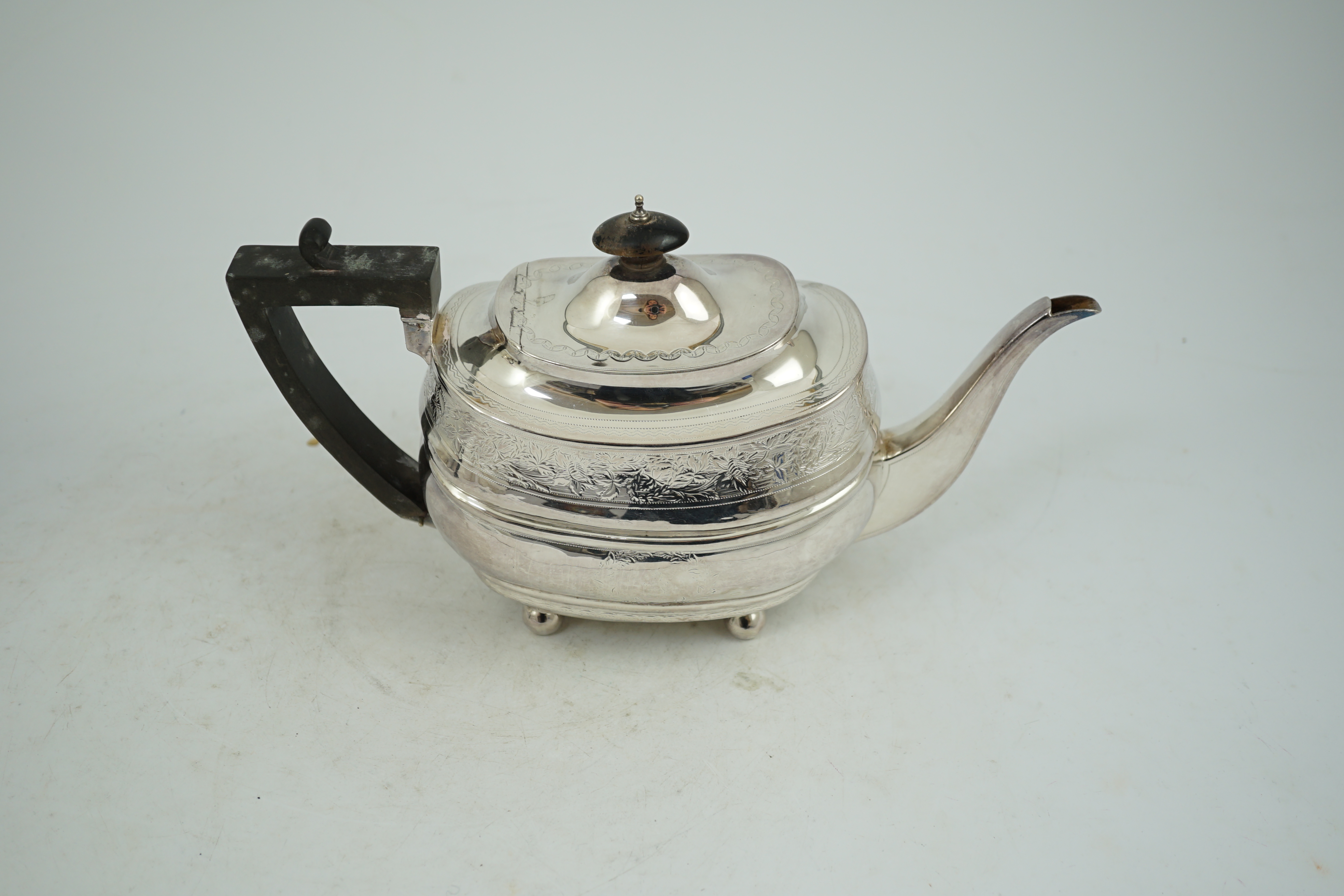 A George III engraved silver shaped oval teapot, on ball feet, Thomas Wallis II, London, 1807, gross weight 16.1oz.